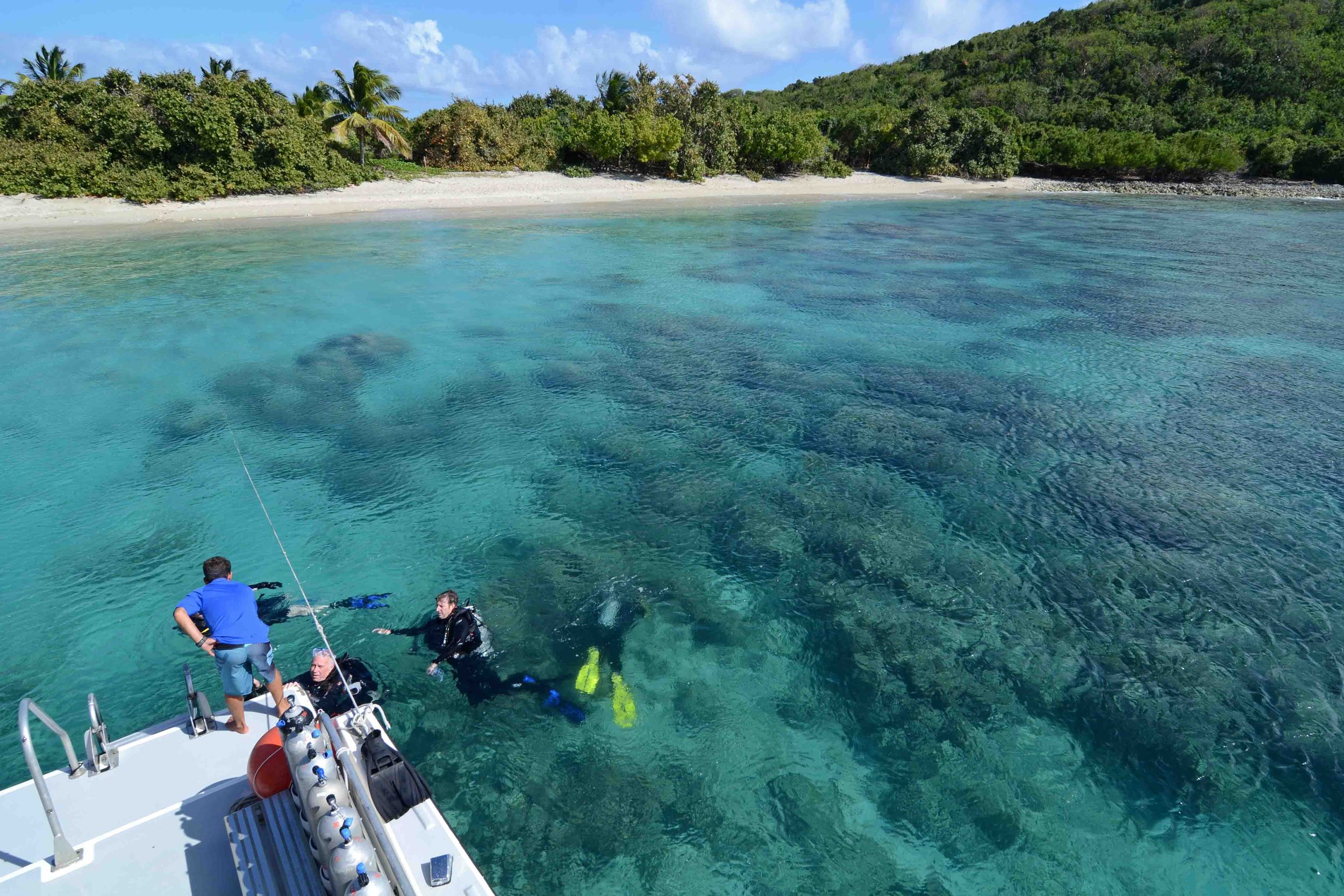 Scuba divers entering clear water off a dive boat, Culebra, Puerto Rico